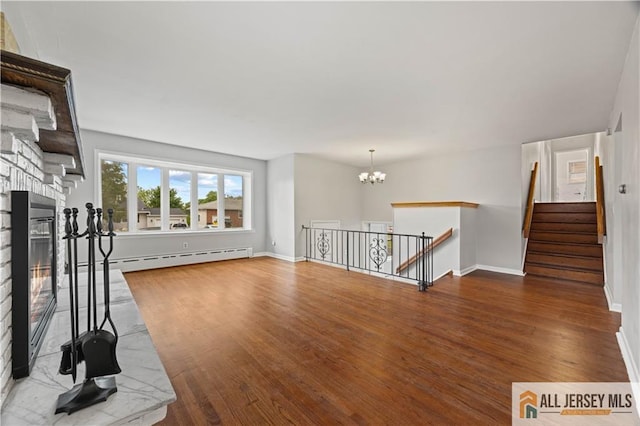 11 Amendola Dr, Netcong, NJ 07857 - unfurnished living room featuring wood finished floors, a fireplace, a chandelier, and baseboard heating