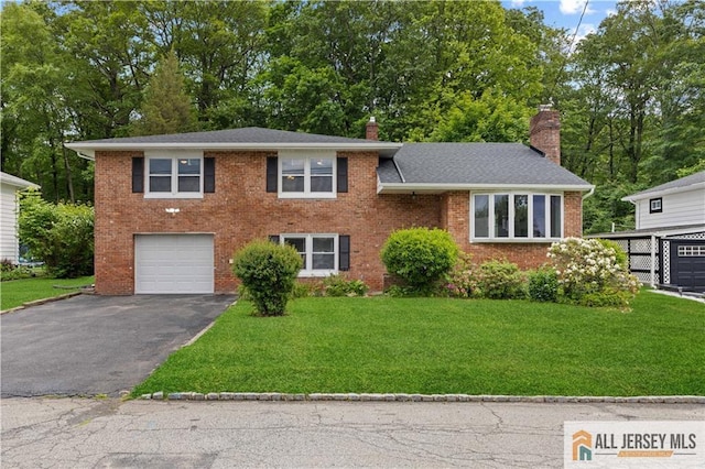 11 Amendola Dr, Netcong, NJ 07857 - tri-level home with a chimney, driveway, an attached garage, a front yard, and brick siding