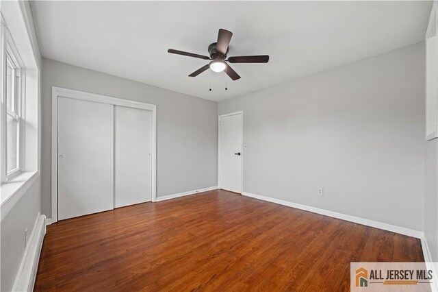 11 Amendola Dr, Netcong, NJ 07857 - unfurnished bedroom with a baseboard heating unit, baseboards, wood finished floors, and a closet