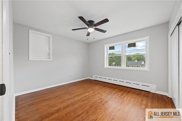11 Amendola Dr, Netcong, NJ 07857 - unfurnished bedroom featuring baseboard heating, wood finished floors, baseboards, and a closet