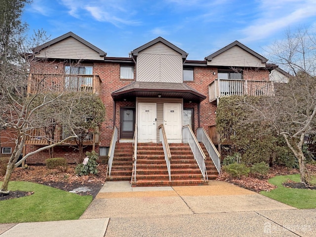 view of property with a balcony and brick siding