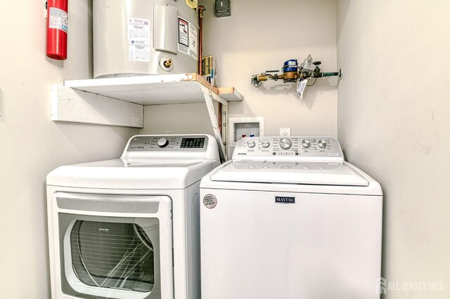 clothes washing area featuring gas water heater and independent washer and dryer