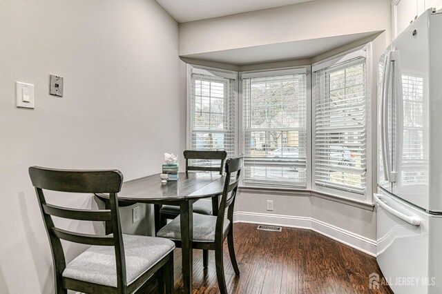 dining room with dark hardwood / wood-style floors and plenty of natural light