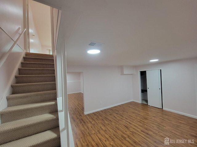 staircase with hardwood / wood-style flooring