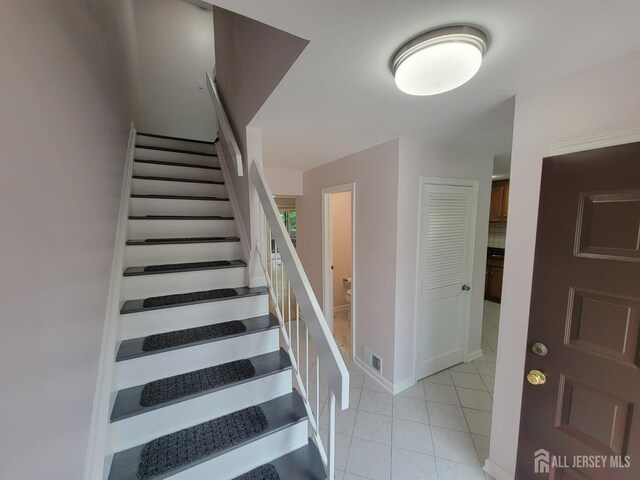 stairs with tile patterned floors