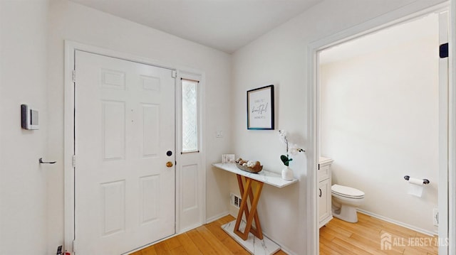 entryway featuring visible vents, light wood-style flooring, and baseboards