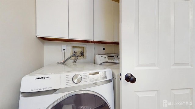 laundry room featuring washer and clothes dryer and cabinet space