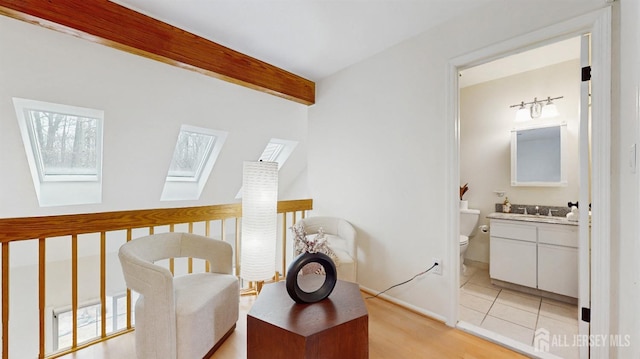 interior space featuring a skylight and beamed ceiling