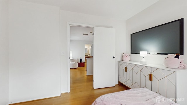 bedroom featuring visible vents and wood finished floors