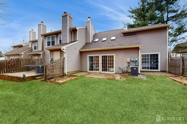 back of house featuring a shingled roof, a lawn, central AC unit, a patio area, and fence