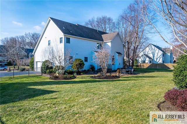 back of property with a garage and a lawn