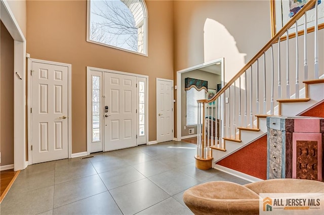 foyer entrance featuring a towering ceiling and plenty of natural light