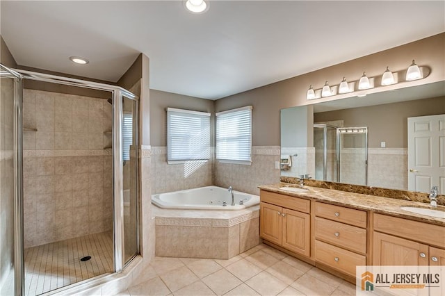 bathroom featuring tile patterned floors, shower with separate bathtub, tile walls, and vanity