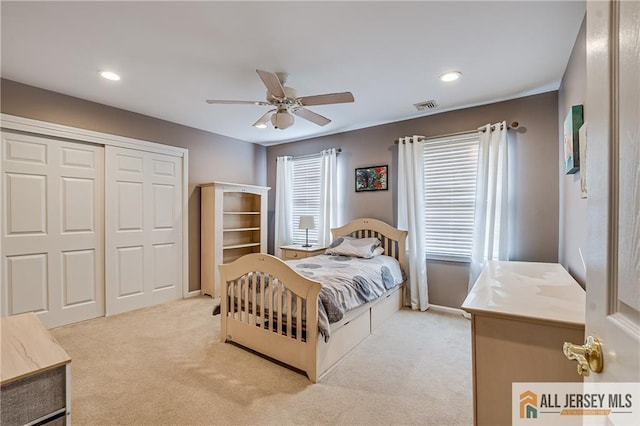 carpeted bedroom with a closet and ceiling fan