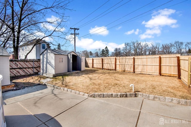 view of yard with a fenced backyard, a storage unit, an outdoor structure, and a patio