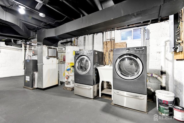 unfinished basement with water heater, heating unit, washing machine and dryer, and concrete block wall