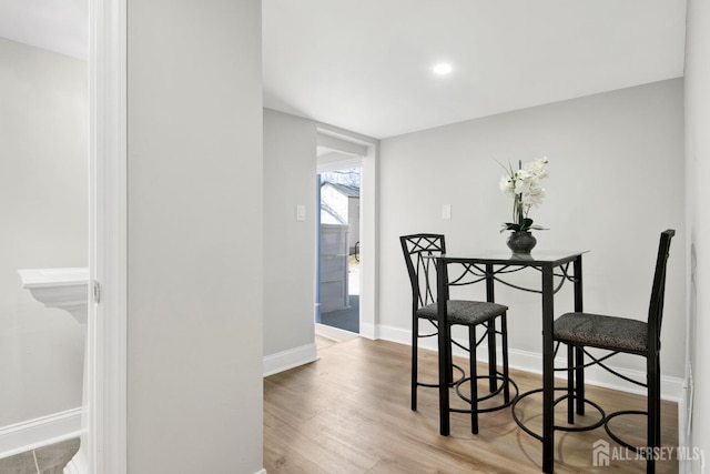 dining space featuring wood finished floors and baseboards