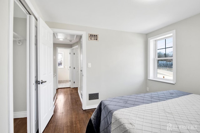 bedroom with visible vents, baseboards, and dark wood-style floors