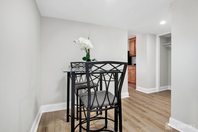 dining area featuring baseboards and light wood finished floors