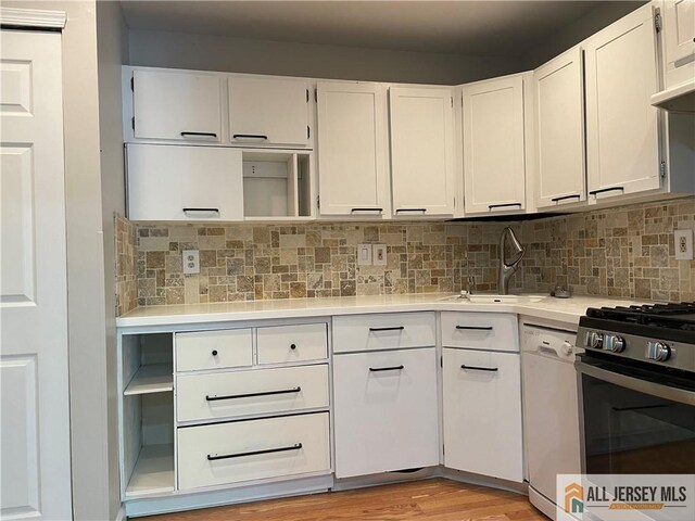 38 Brighton Way N, Brunswick, NJ 08902 - kitchen with white dishwasher, gas range, light countertops, white cabinetry, and tasteful backsplash