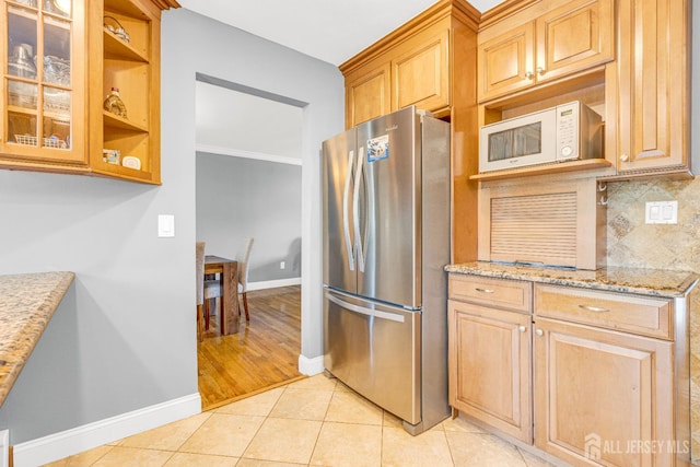 11 Eagle Rd, Edison, NJ 08820 - kitchen featuring freestanding refrigerator, white microwave, backsplash, light stone countertops, and glass insert cabinets