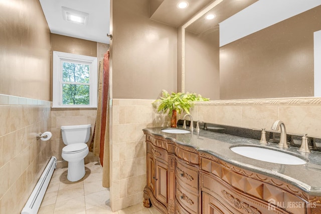 11 Eagle Rd, Edison, NJ 08820 - full bath featuring a baseboard heating unit, tile walls, double vanity, tile patterned flooring, and a wainscoted wall