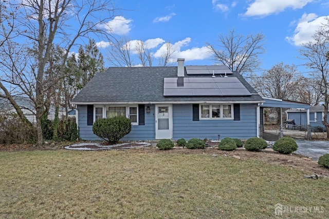 view of front of home with a front yard and solar panels