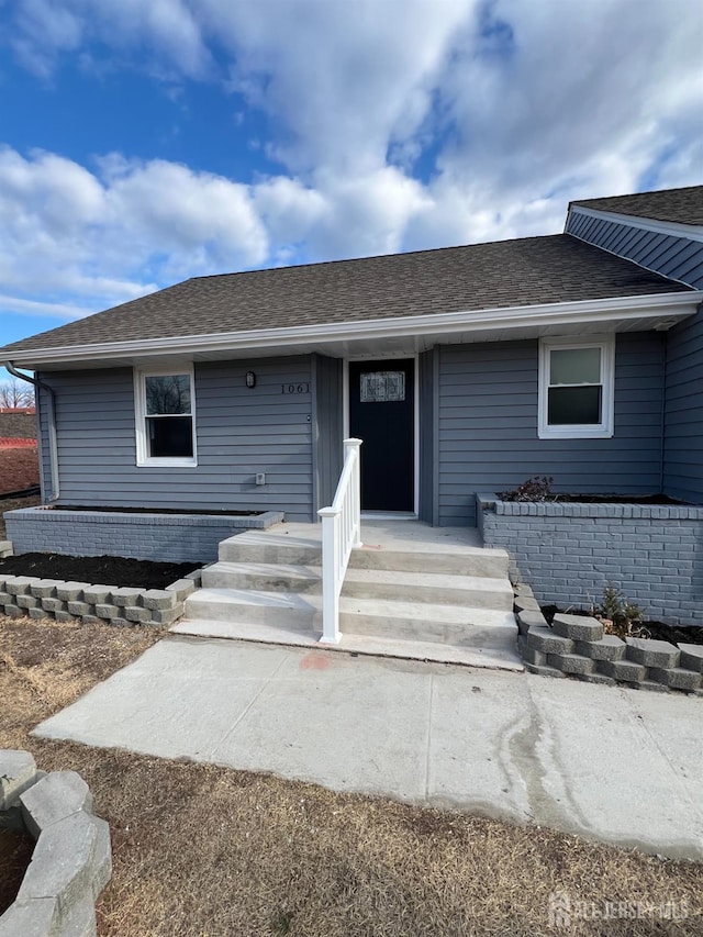 view of front of home with covered porch and roof with shingles