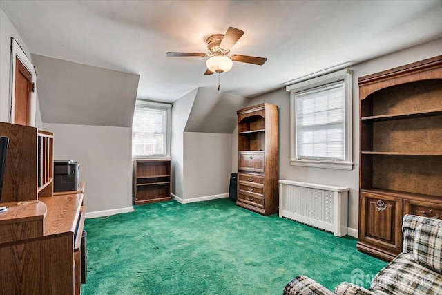 interior space featuring lofted ceiling, ceiling fan, radiator heating unit, and dark carpet