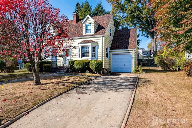 new england style home featuring a garage and a front lawn