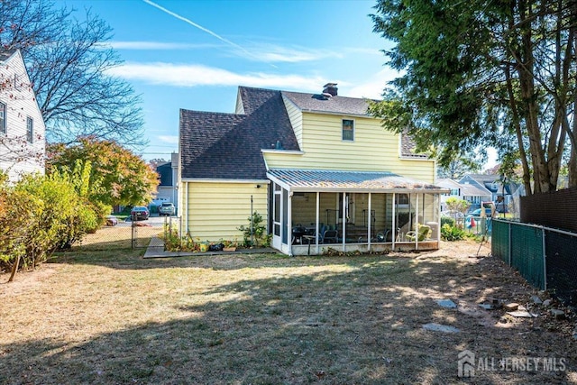 back of house with a lawn and a sunroom