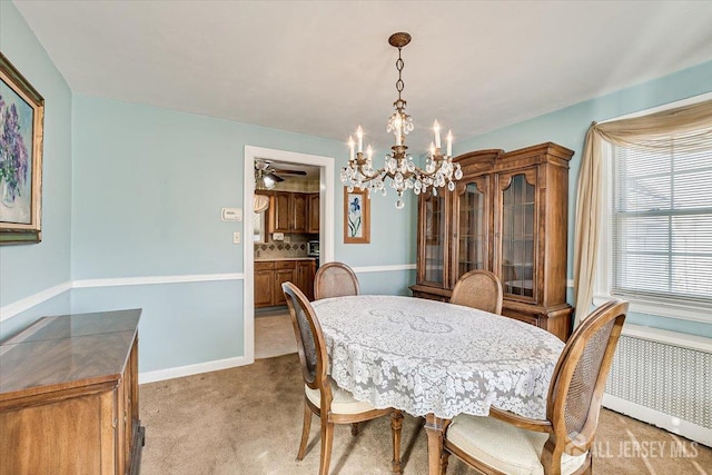 dining area with radiator, light carpet, and ceiling fan with notable chandelier