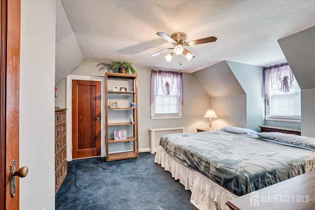 bedroom featuring radiator, ceiling fan, vaulted ceiling, and dark carpet