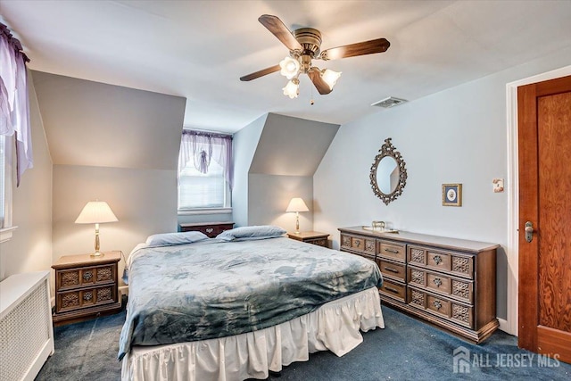 bedroom featuring dark colored carpet, lofted ceiling, and ceiling fan