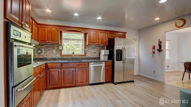 9 Salem Rd, East Brunswick, NJ 08816 - kitchen featuring appliances with stainless steel finishes, a warming drawer, a sink, light wood-style flooring, and tasteful backsplash