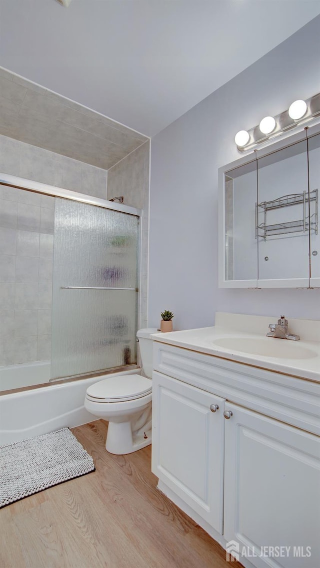9 Salem Rd, East Brunswick, NJ 08816 - full bath with vanity, wood finished floors, toilet, and combined bath / shower with glass door
