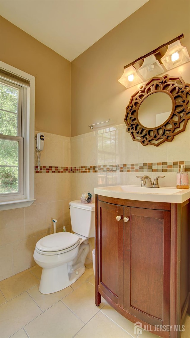 9 Salem Rd, East Brunswick, NJ 08816 - half bathroom featuring vanity, toilet, tile walls, tile patterned floors, and wainscoting