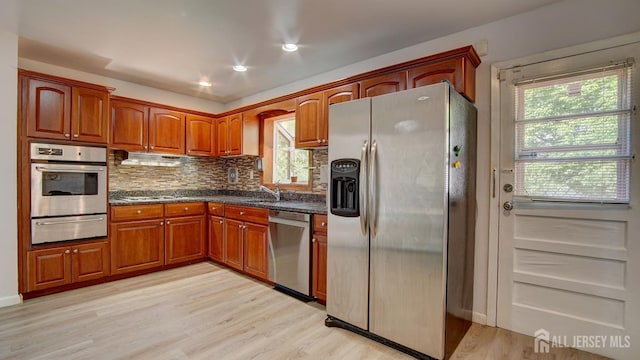 9 Salem Rd, East Brunswick, NJ 08816 - kitchen with appliances with stainless steel finishes, a warming drawer, decorative backsplash, a sink, and light wood-style flooring