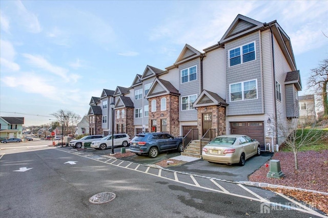 238 Main St, South Amboy, NJ 08879 - view of front of house with a residential view, stone siding, and an attached garage