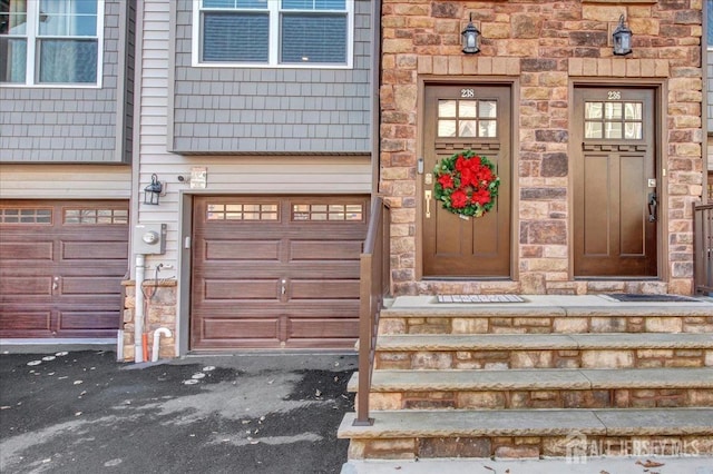 238 Main St, South Amboy, NJ 08879 - entrance to property featuring an attached garage, asphalt driveway, and stone siding
