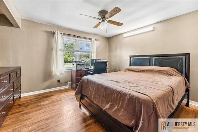 bedroom featuring wood finished floors, baseboards, and a ceiling fan