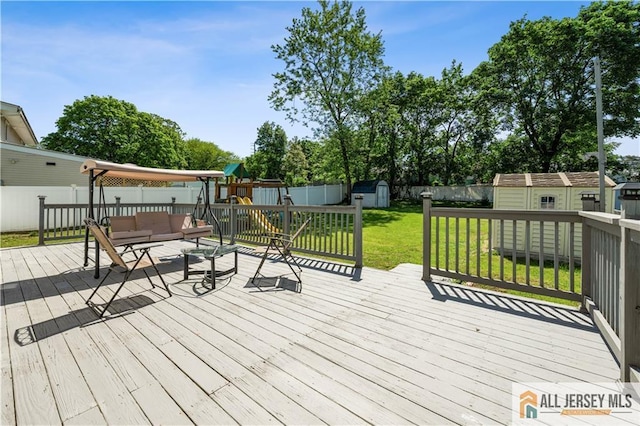 wooden terrace featuring a storage shed, a playground, an outdoor structure, and an outdoor hangout area