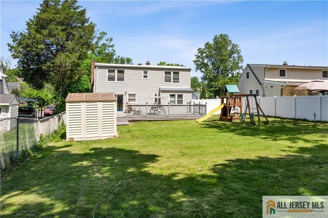 back of property with a playground, a storage unit, an outdoor structure, a wooden deck, and a chimney