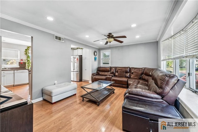living area with healthy amount of natural light, a ceiling fan, recessed lighting, light wood finished floors, and crown molding