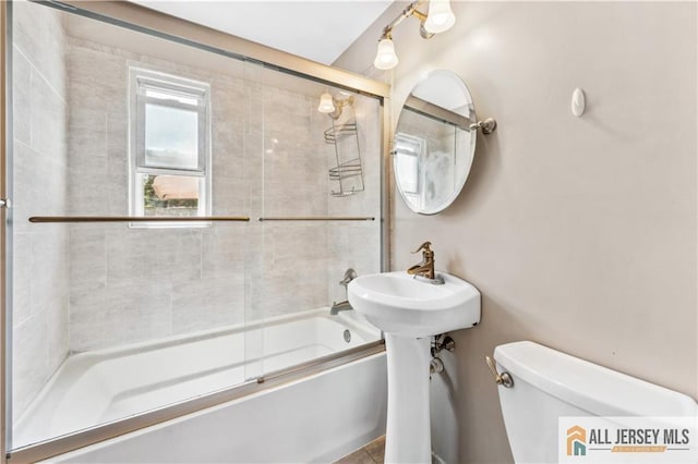 bathroom featuring toilet and enclosed tub / shower combo