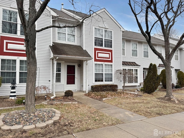 townhome / multi-family property featuring roof with shingles