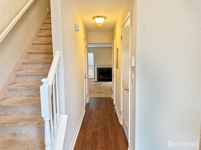 interior space with dark wood finished floors, stairway, and baseboards