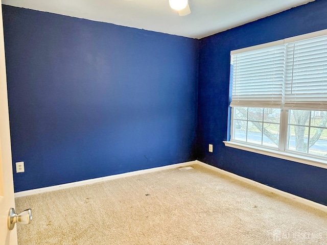 spare room featuring carpet flooring and baseboards