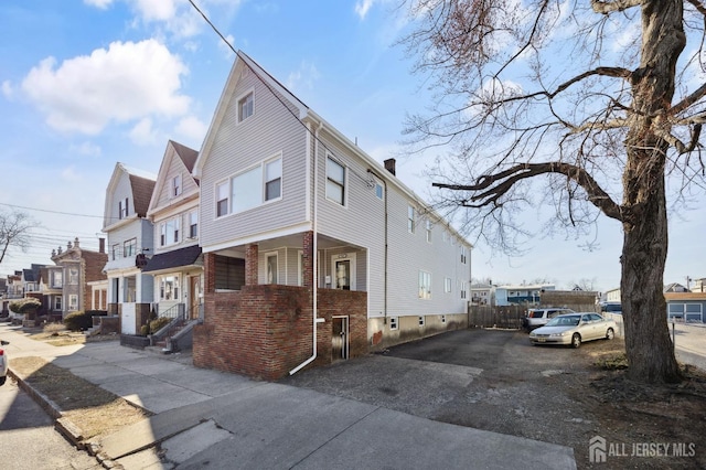 view of property exterior featuring a residential view, brick siding, and a chimney