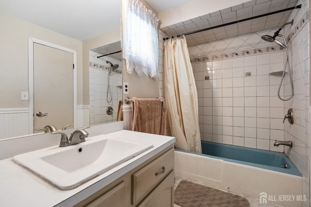 full bath featuring shower / bath combination with curtain, a wainscoted wall, and vanity